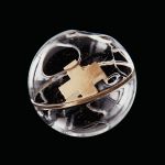 Golden ashes contained in a melted plastic ball.